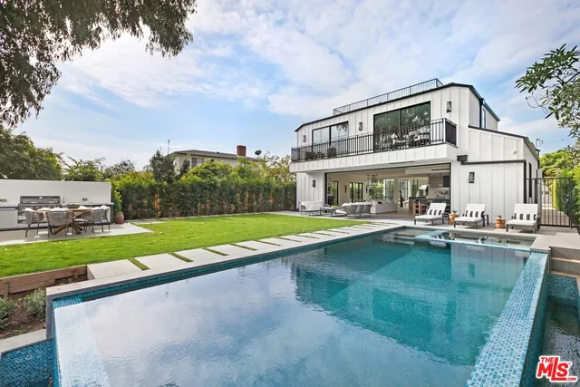 a view of house with yard and swimming pool