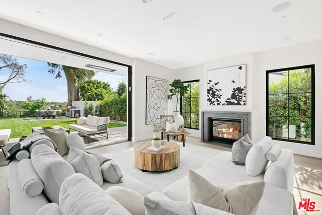 a living room with furniture fireplace and a large window