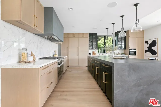 a large kitchen with stainless steel appliances lots of counter space and a sink