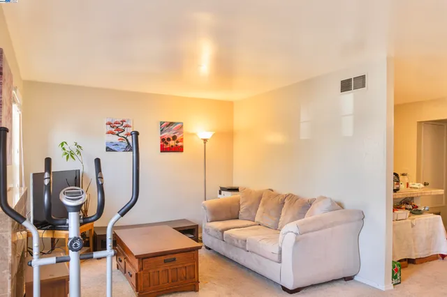 a living room with furniture a flat screen tv and a window