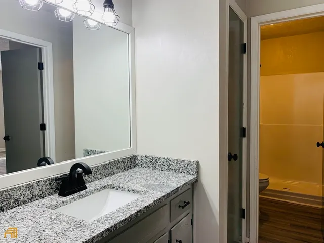 a bathroom with a granite countertop sink and a mirror