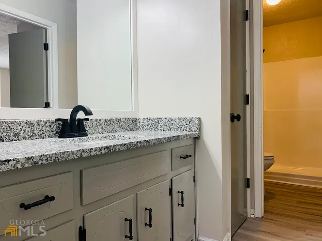 a bathroom with a granite countertop sink and a mirror