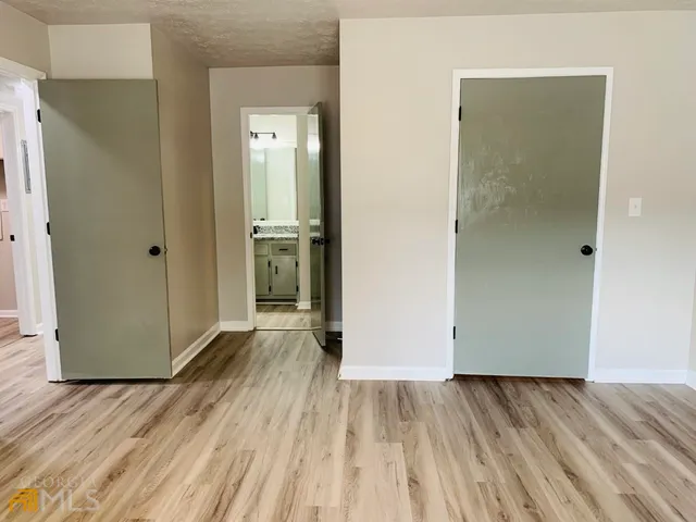 a view of a room with wooden floor and a bathroom