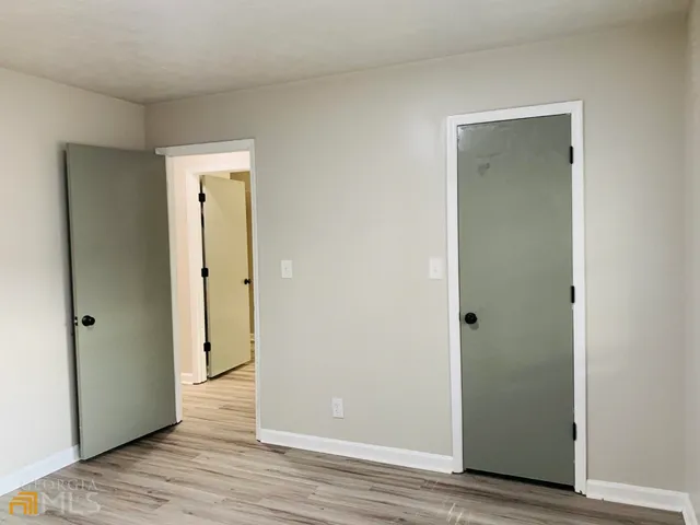 an empty room with wooden floor and closet