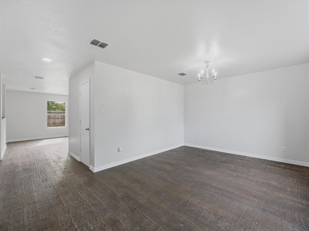 12134 Shine Avenue Rhome, TX 76078 - Photo 13 of 33 an empty room with wooden floor and chandelier fan