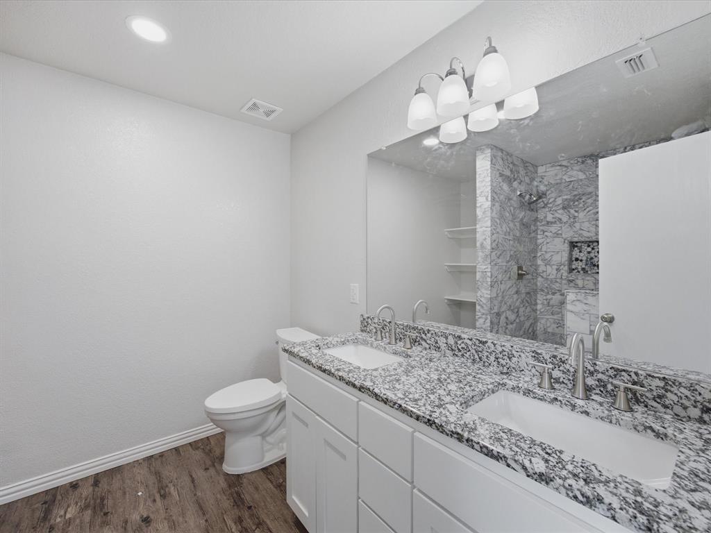 12134 Shine Avenue Rhome, TX 76078 - Photo 15 of 33 a bathroom with a granite countertop sink a toilet and a mirror