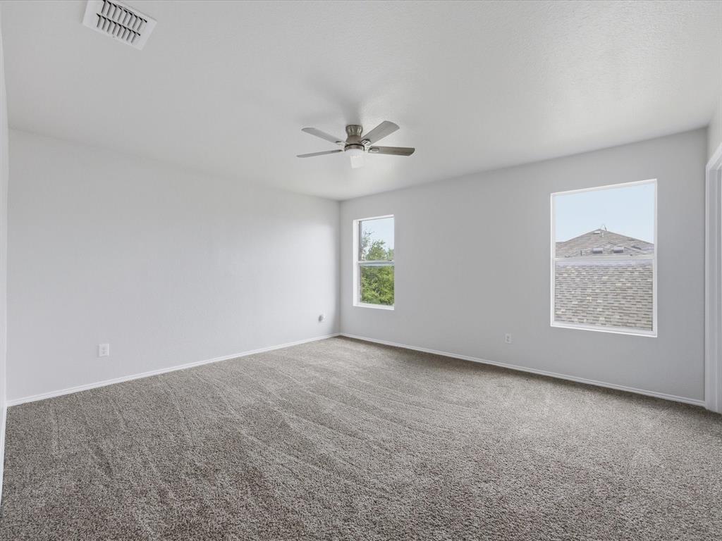 12134 Shine Avenue Rhome, TX 76078 - Photo 18 of 33 an empty room with windows and fan