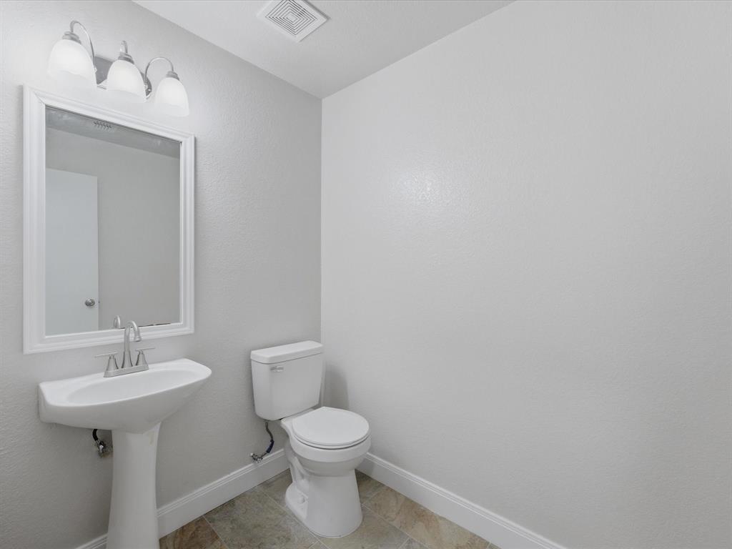 12134 Shine Avenue Rhome, TX 76078 - Photo 29 of 33 a bathroom with a toilet sink and mirror