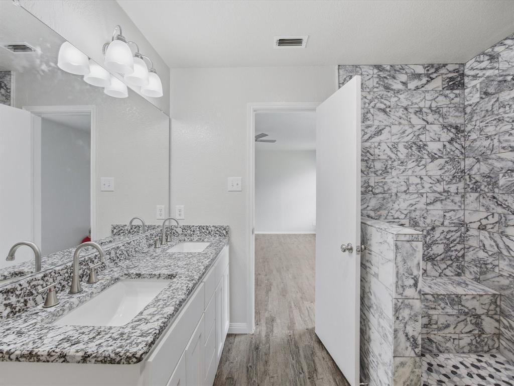 12134 Shine Avenue Rhome, TX 76078 - Photo 3 of 33 a bathroom with a granite countertop sink a mirror and shower