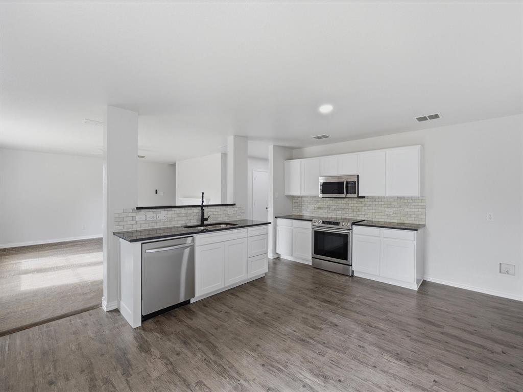 12134 Shine Avenue Rhome, TX 76078 - Photo 5 of 33 a large white kitchen with stainless steel appliances granite countertop a stove and a sink