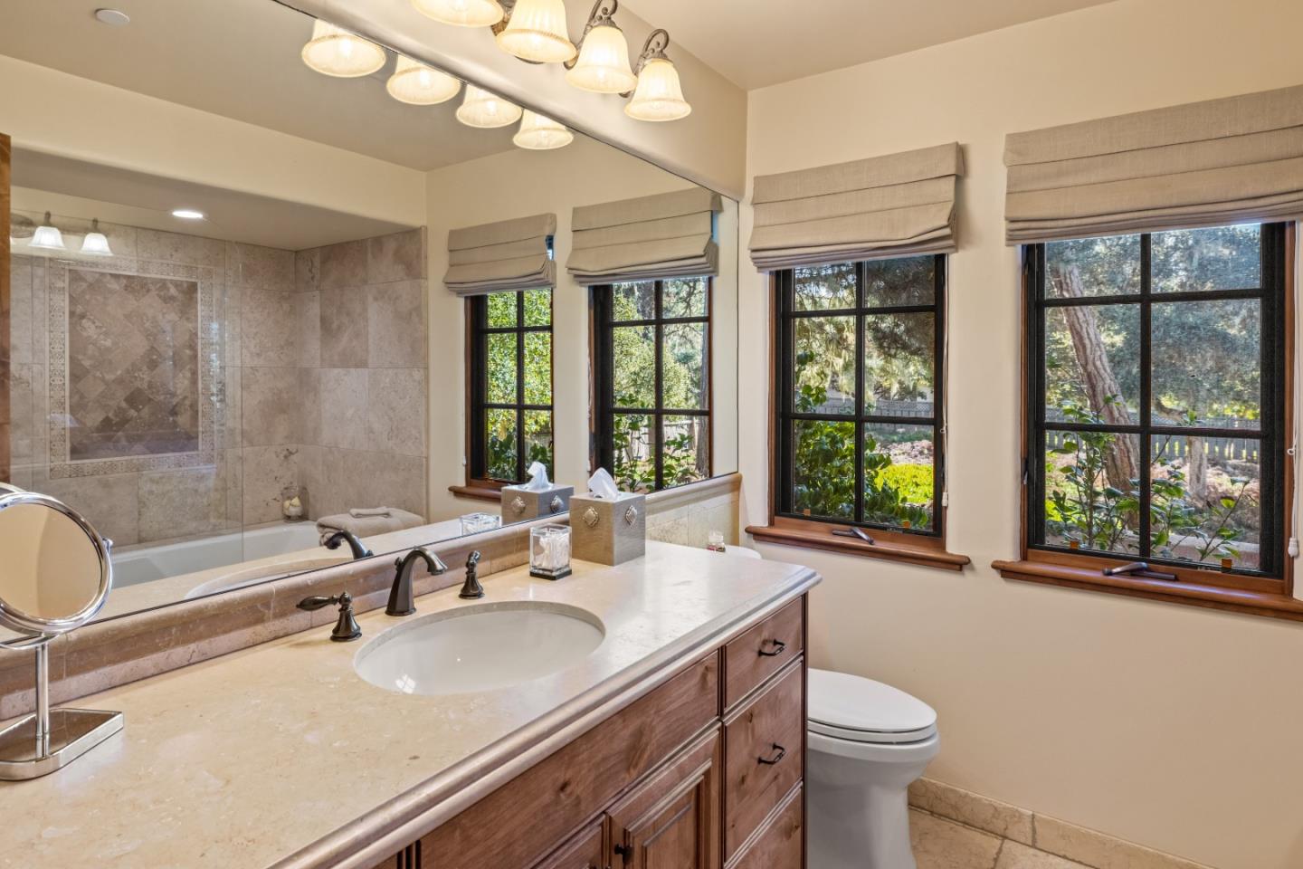 3116 Bird Rock Road Pebble Beach, CA 93953 - Photo 17 of 37 a bathroom with a sink a toilet a large mirror and a large window