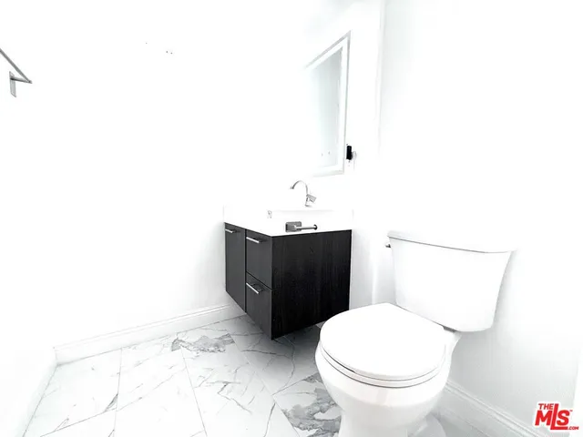 a bathroom with a sink a toilet and mirror