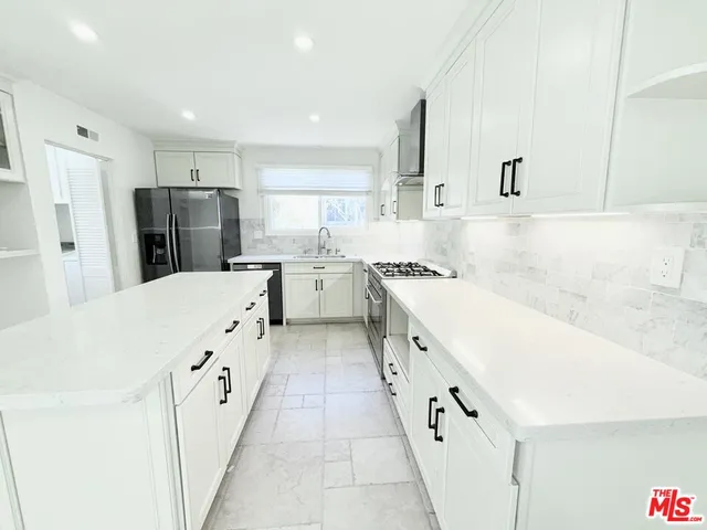 a kitchen with stainless steel appliances a refrigerator sink and cabinets