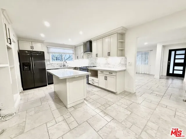 a large white kitchen with a stove a refrigerator a sink and a counter top space