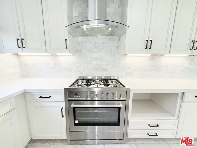 a stove top oven sitting inside of a kitchen