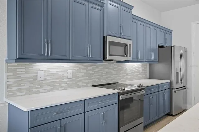 a kitchen with stainless steel appliances a sink and large window