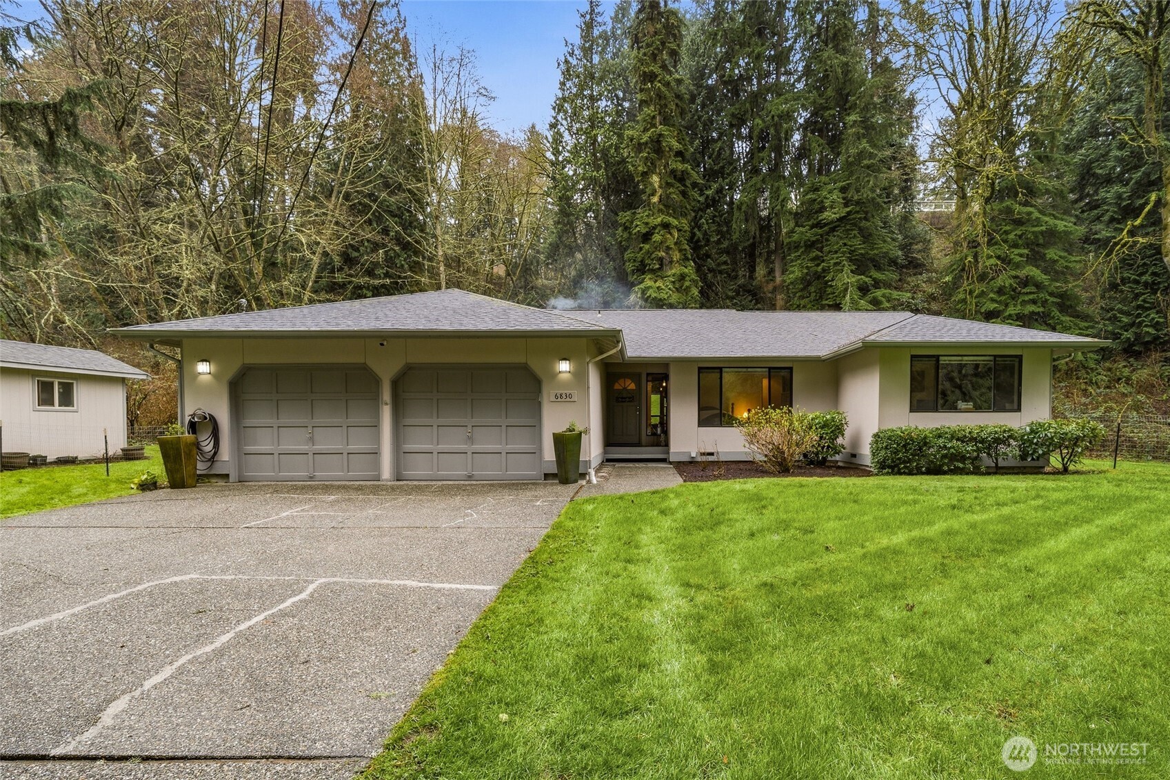 6830 Norma Beach Road Edmonds, WA 98026 - Photo 1 of 30 a front view of a house with a garden and trees