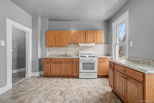 a kitchen with stainless steel appliances granite countertop a refrigerator sink stove and cabinets