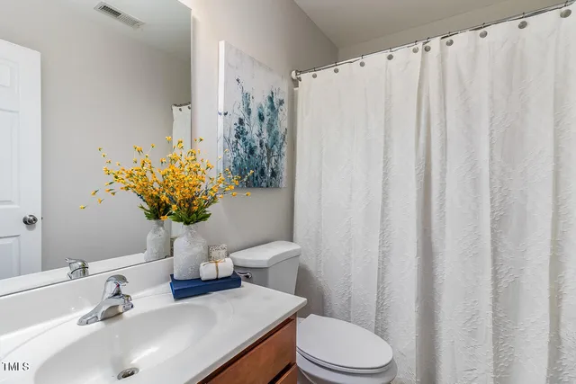 a bathroom with a sink mirror and toilet