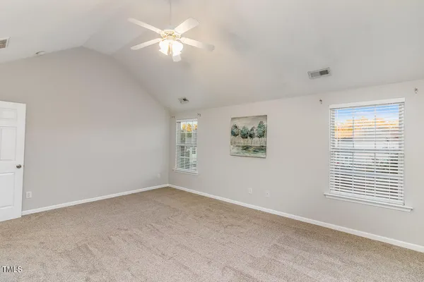an empty room with chandelier fan