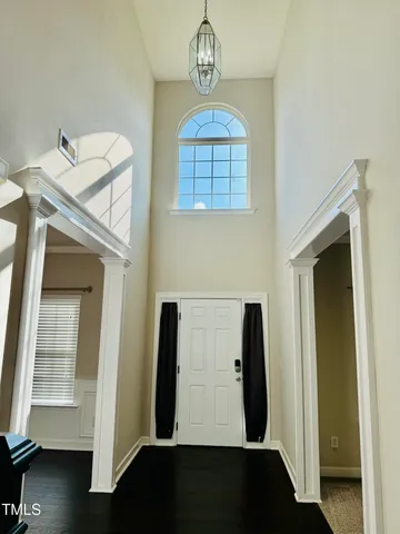 a view of a hallway with entryway wooden floor and front door