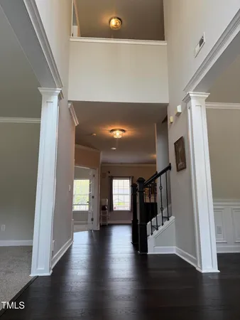 a view of a hallway with wooden floor and stairs