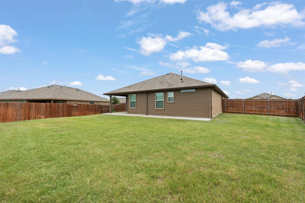 4600 Fringetree Way Crowley, TX 76036 - Photo 30 of 40 Expansive backyard featuring a lush lawn, privacy fencing, a covered patio, and a blend of brick and siding exterior finishes