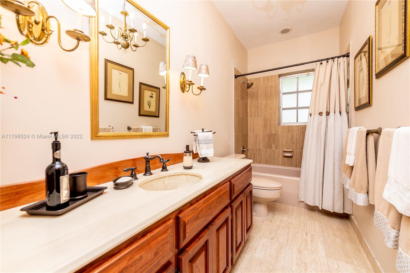 12440 Old Cutler Road Pinecrest, FL 33156 - Photo 35 of 54 a bathroom with a sink a toilet and a mirror
