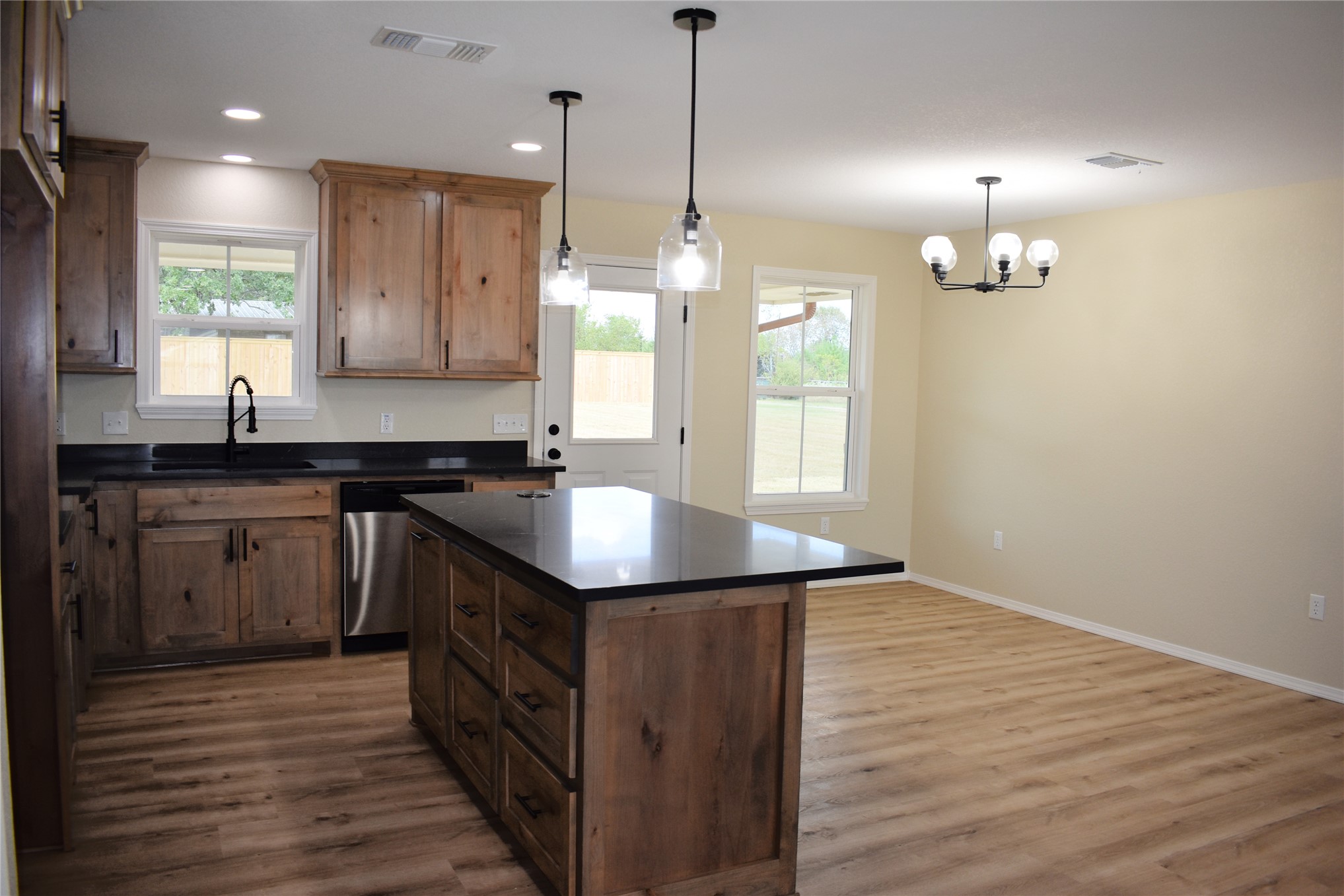 2915 East 2090 Road, Unit LOT 1 Hugo, OK 74743 - Photo 9 of 28 Spacious kitchen with a central island, wood-finish cabinetry, dark countertops, and stainless steel appliances