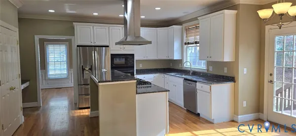 a kitchen with kitchen island granite countertop a refrigerator oven a sink and a cabinets