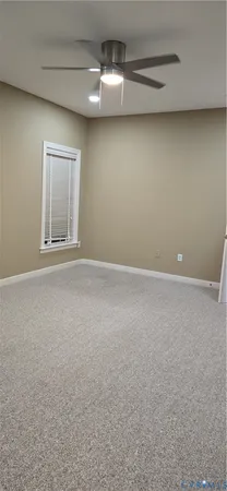 a view of an empty room with a chandelier fan