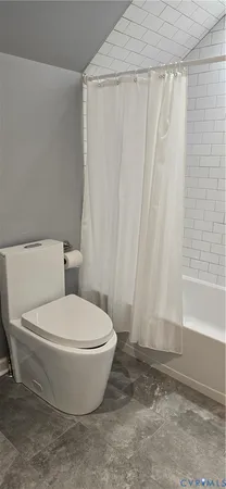 a white toilet sitting next to a shower curtain