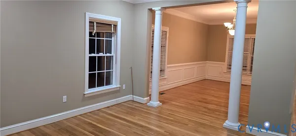 an empty room with wooden floor and a window