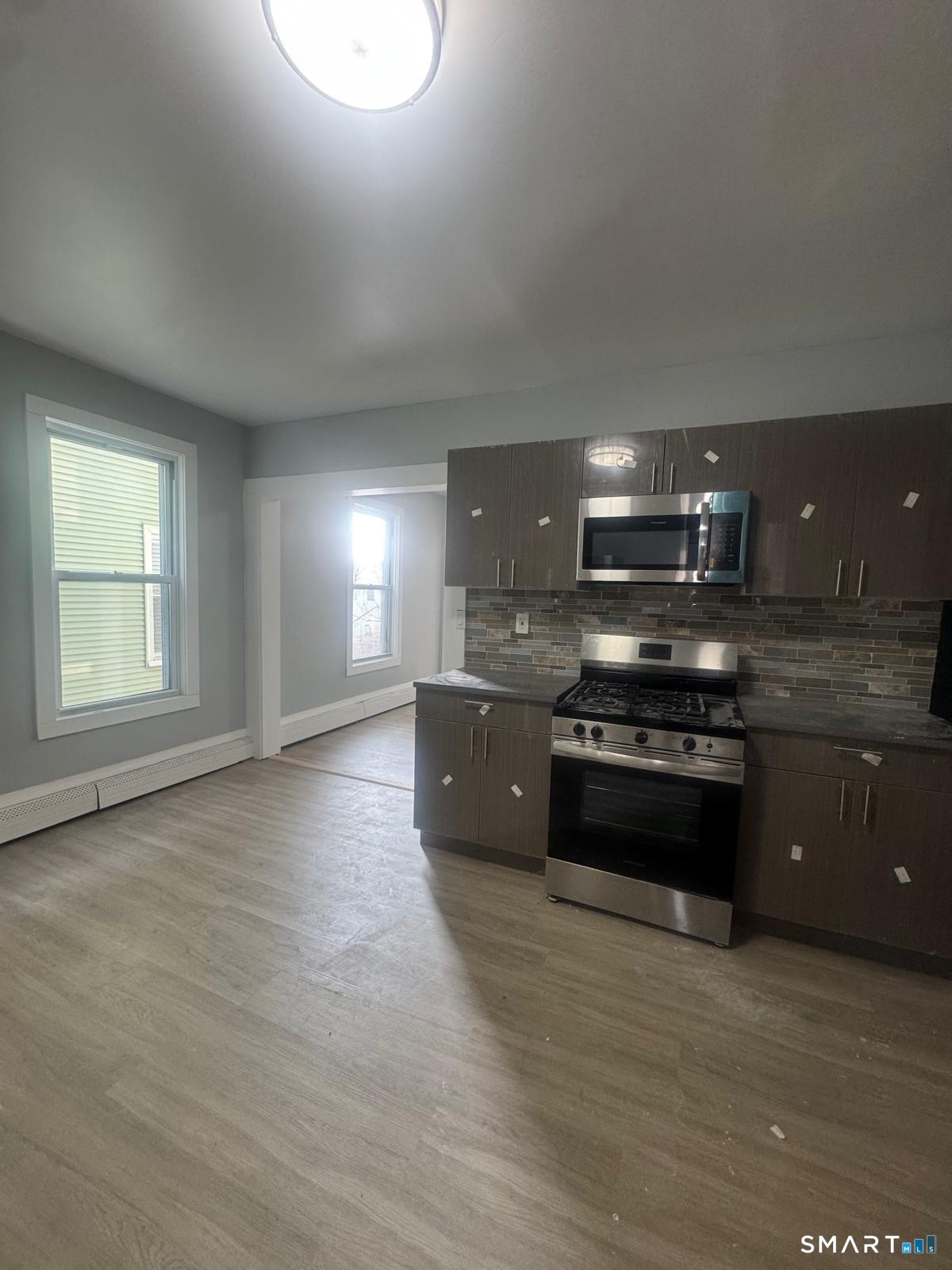 a large kitchen with stainless steel appliances granite countertop a stove a sink and a microwave