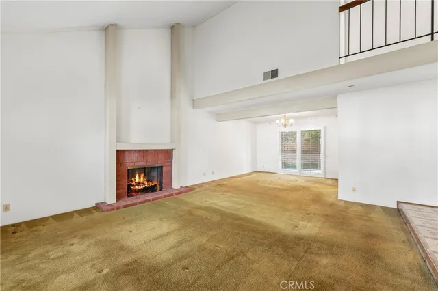 a view of an empty room with a fireplace and a window