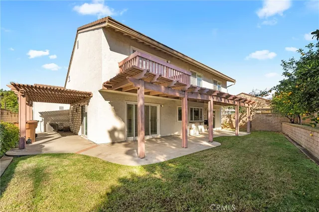 a view of a backyard with couches plants and large trees