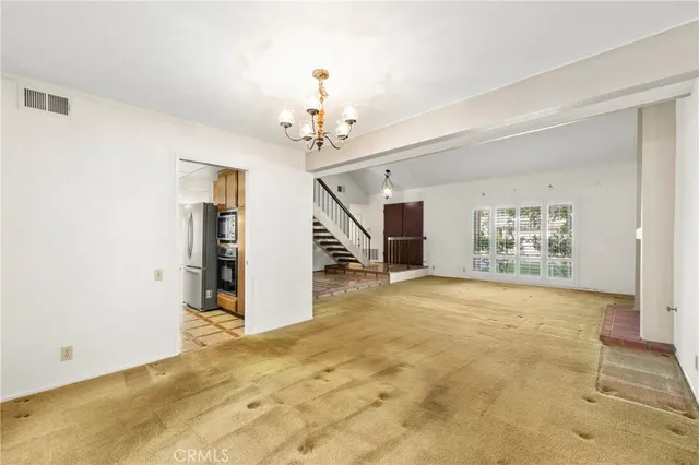 a view of a livingroom with a chandelier fan and a window