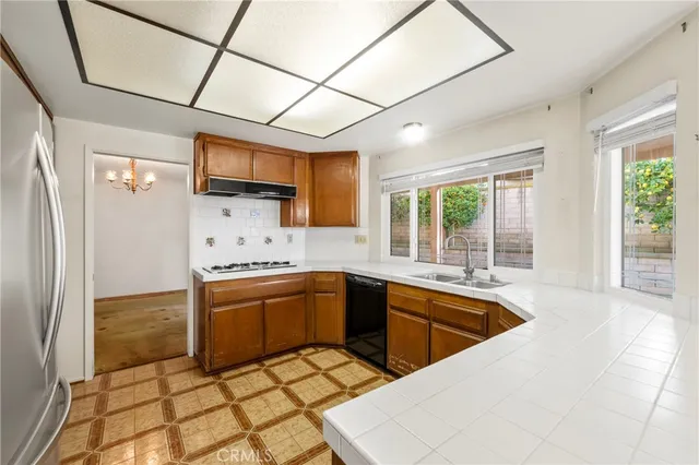 a kitchen with stainless steel appliances wooden floor and a refrigerator