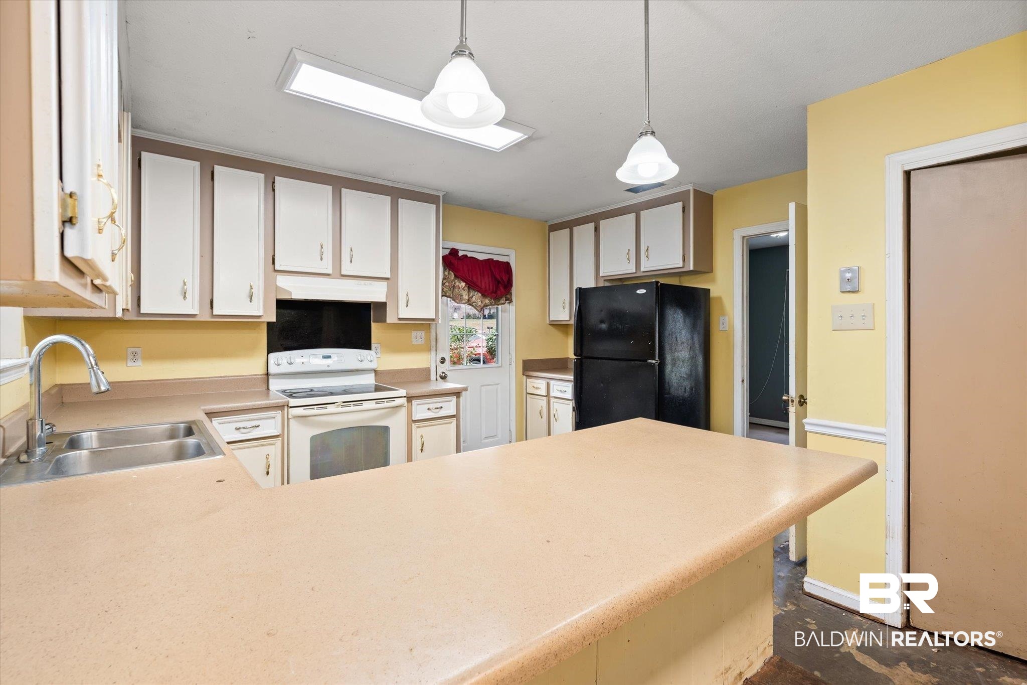 3541 Winston Drive Semmes, AL 36575 - Photo 6 of 20 Kitchen featuring white electric stove, freestanding refrigerator, light countertops, pendant lighting, and a sink