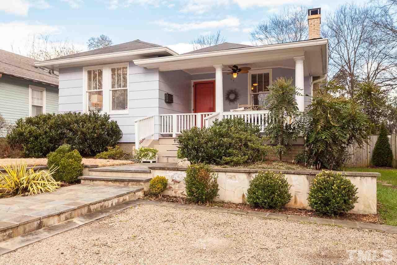 1702 Dare Street Raleigh, NC 27608 - Photo 2 of 25 a view of a white house with a large windows and a yard with plants