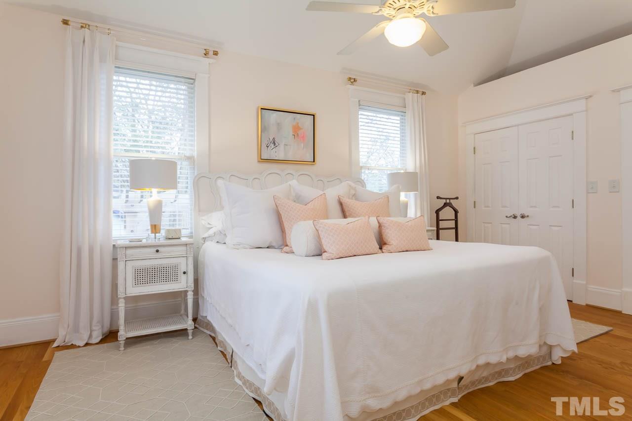 1702 Dare Street Raleigh, NC 27608 - Photo 13 of 25 a bedroom with a bed and a chandelier