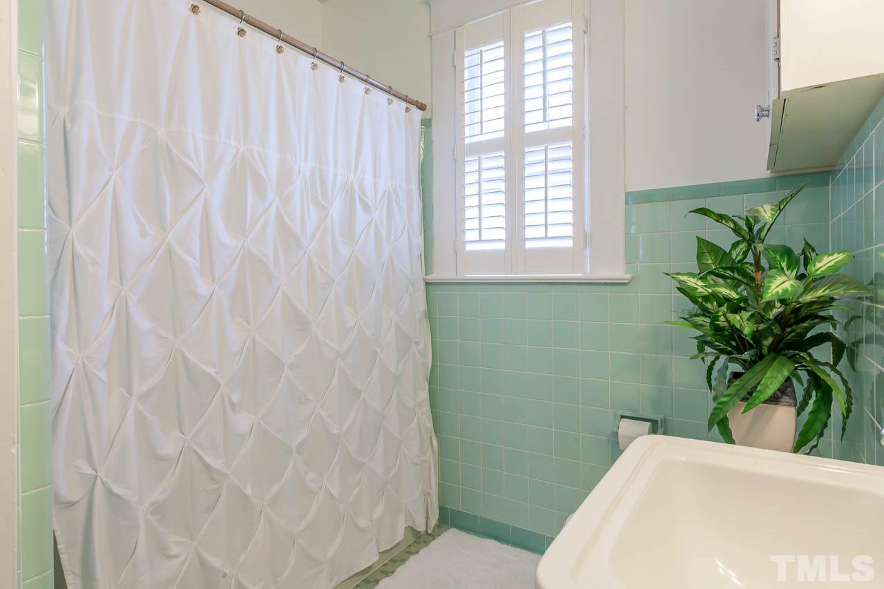 1702 Dare Street Raleigh, NC 27608 - Photo 19 of 25 a bathroom with a sink a toilet and a window