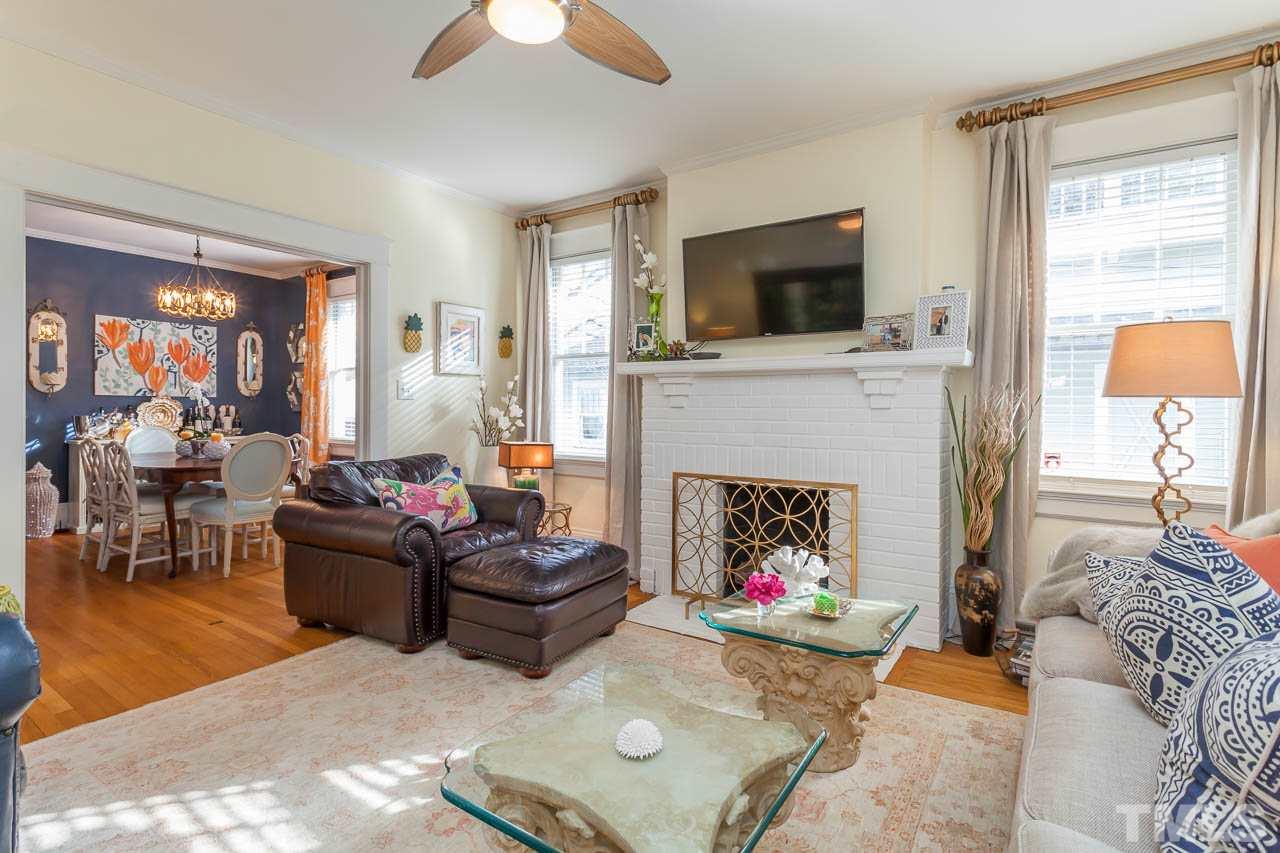 1702 Dare Street Raleigh, NC 27608 - Photo 6 of 25 a living room with furniture a flat screen tv and a fireplace