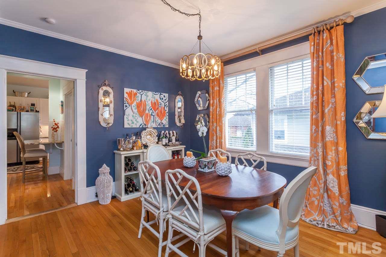 1702 Dare Street Raleigh, NC 27608 - Photo 9 of 25 a dining room with wooden floor a chandelier a glass table and chairs