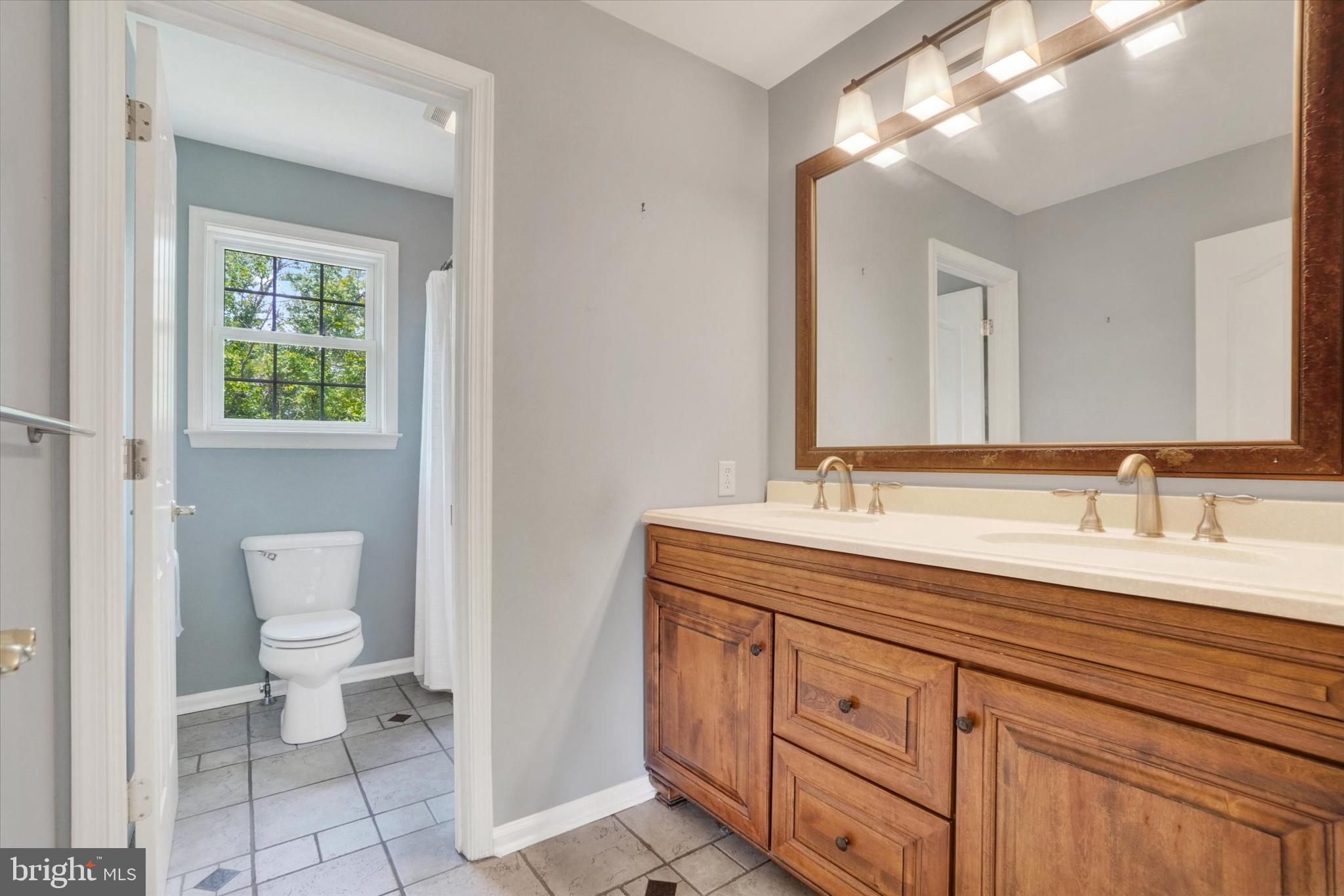 857 Willow Ridge Court York, PA 17404 - Photo 23 of 27 a spacious bathroom with a toilet a double vanity sink and a mirror