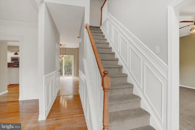 a view of staircase with railing and white walls