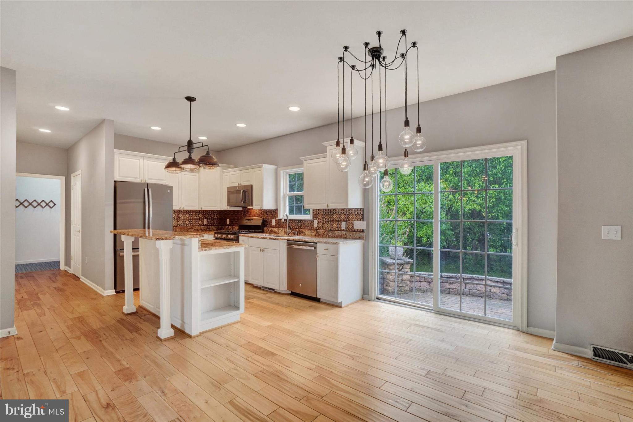 857 Willow Ridge Court York, PA 17404 - Photo 10 of 27 a large kitchen with kitchen island a stove a refrigerator a center island and a wooden floor