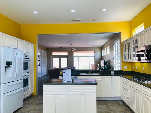a kitchen with stainless steel appliances kitchen island granite countertop a sink and cabinets