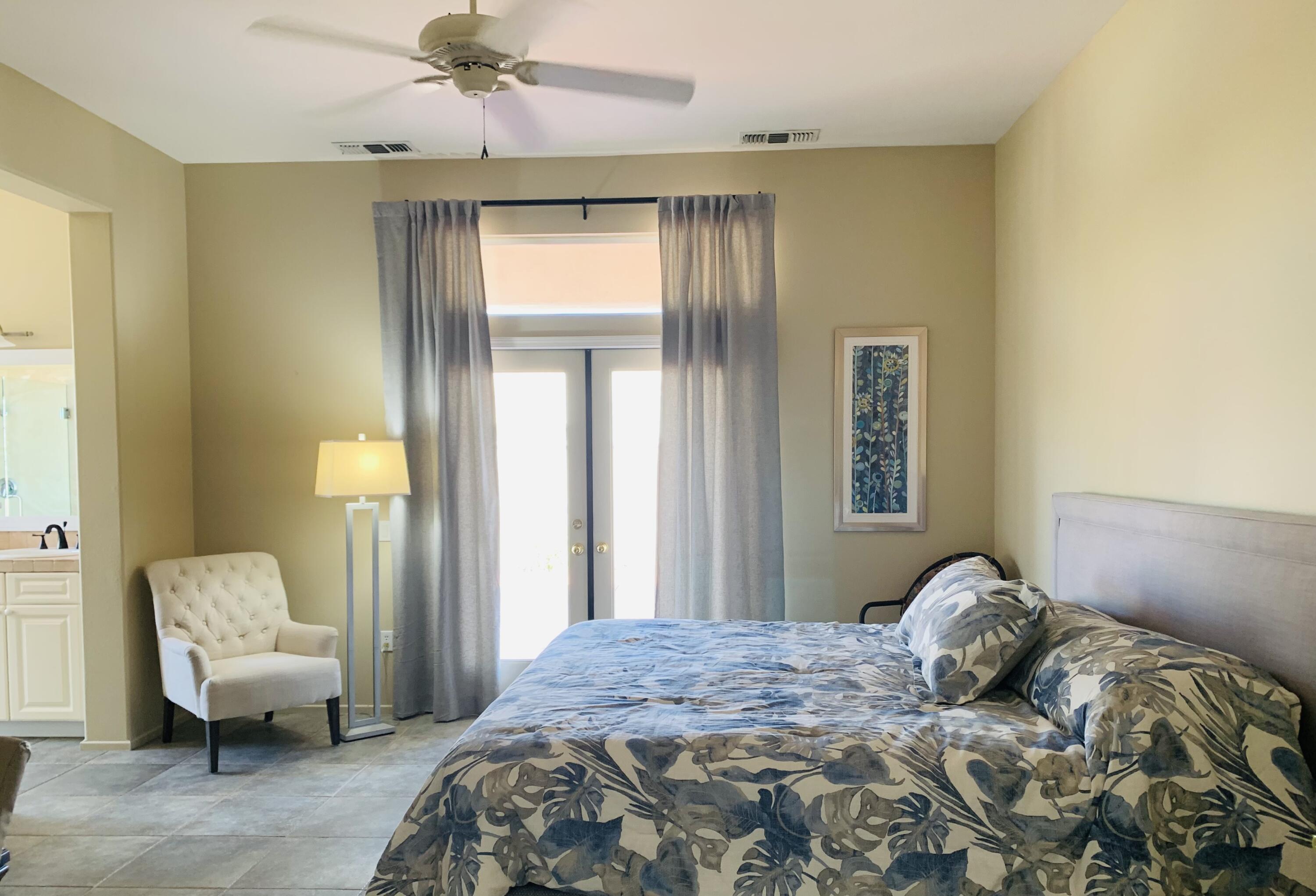 35932 Beringer Road Palm Desert, CA 92211 - Photo 32 of 44 a bedroom with a bed and a chandelier