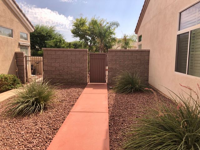 a backyard of a house with a large tree and wooden fence
